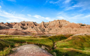 Image depicting the best time to visit Badlands National Park in South Dakota on a sunny day with blue skies