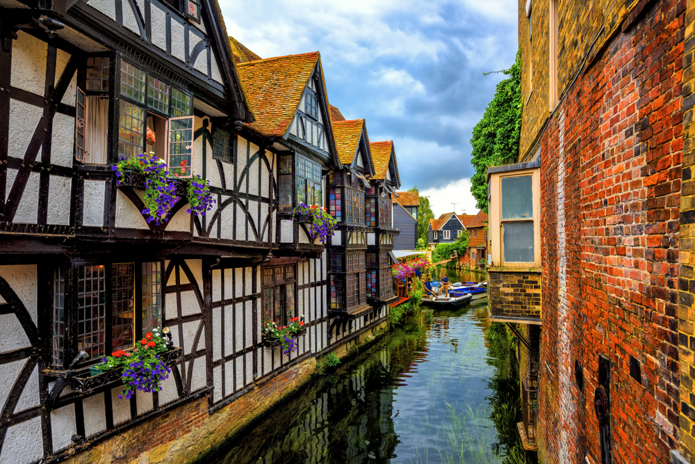 Pictured during the overall best time to visit England, the medieval half-timber houses in Kent overlook a canal