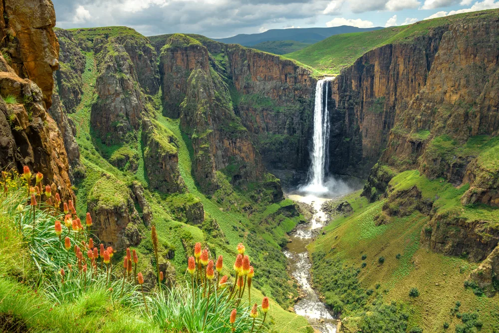 Aerial shot of the Maletsunyane Falls in Lesotho on a clear day with lots of green grass around for a piece on the best time to visit Africa