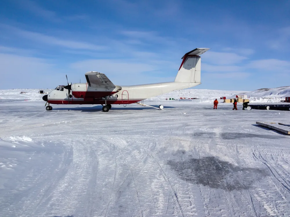Twin-engine airplane sitting on an ice runway during the best time to visit Antarctica