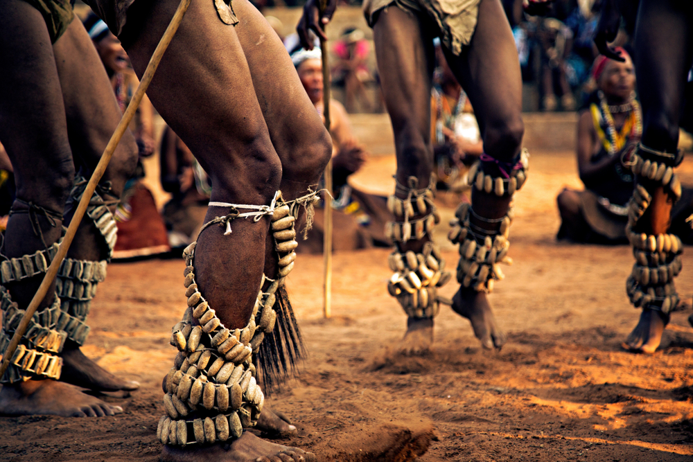 African men performing a traditional dance in loin cloths during the best time to visit Botswana with only legs and plantain jewelry in view