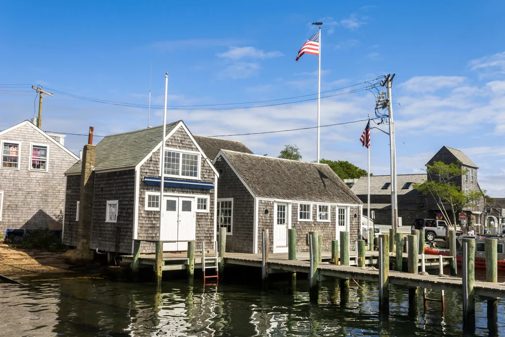Photo of Edgartown on the water with homes and buildings on stilts overlooking the bay with a dock protruding from the front