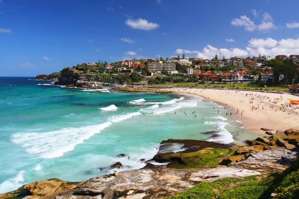 View of Bronte Beach in Sydney pictured on a blue-sky day with a few clouds in the sky