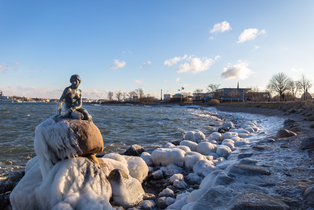 Frozen Little Mermaid statue on the shore during winter, the worst time to visit Copenhagen