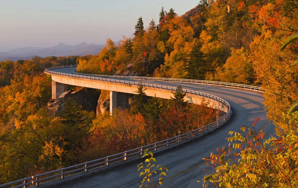 Road winding around the Linn Cove Viaduct at sunrise in the fall, one of the best times to visit North Carolina