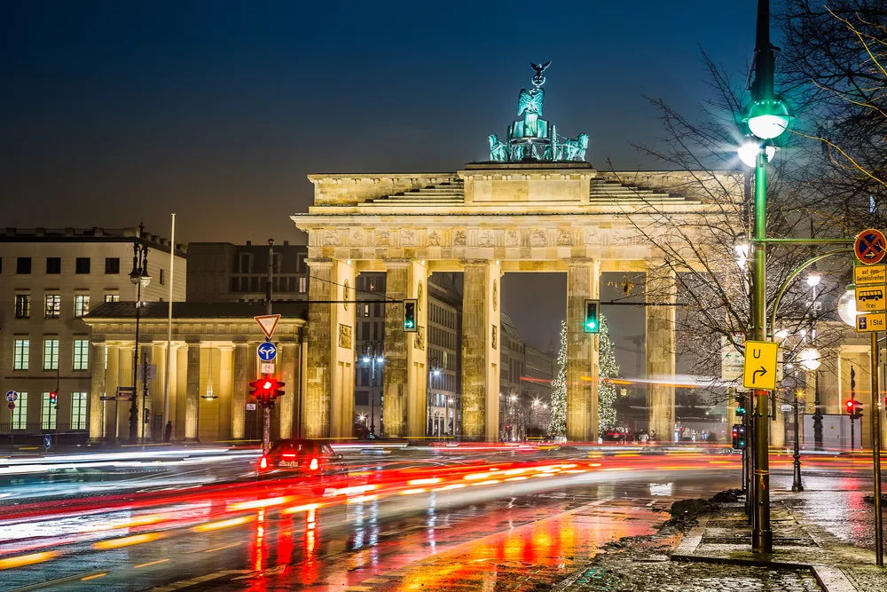 Brandenburg Gate at night with car lights speeding through for a frequently asked questions section on the best time to visit Berlin