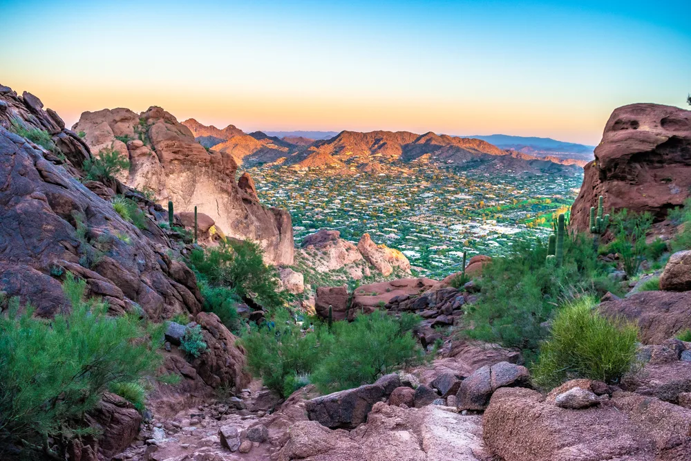 Colorful sunrise over Camelback in Arizona during the summer, the overall cheapest time to visit Phoenix