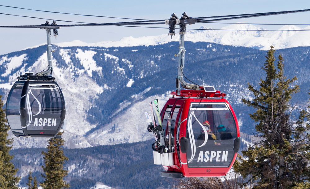 Gondolas in red and grey pictured high above the ski slopes for a piece on the best time to go to Aspen
