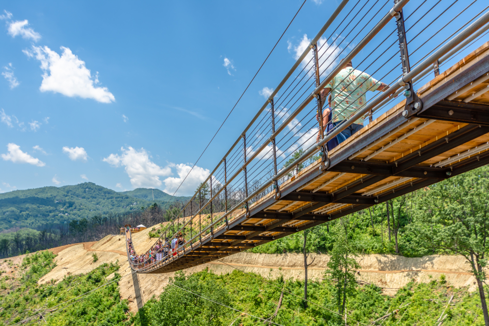 Wooden suspension bridge with people walking on it during the best time to go to Gatlinburg