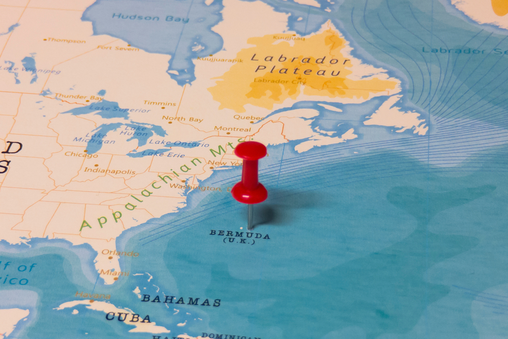 Red pin pushed into a vintage map marking the location of Bermuda in the middle of the Caribbean ocean