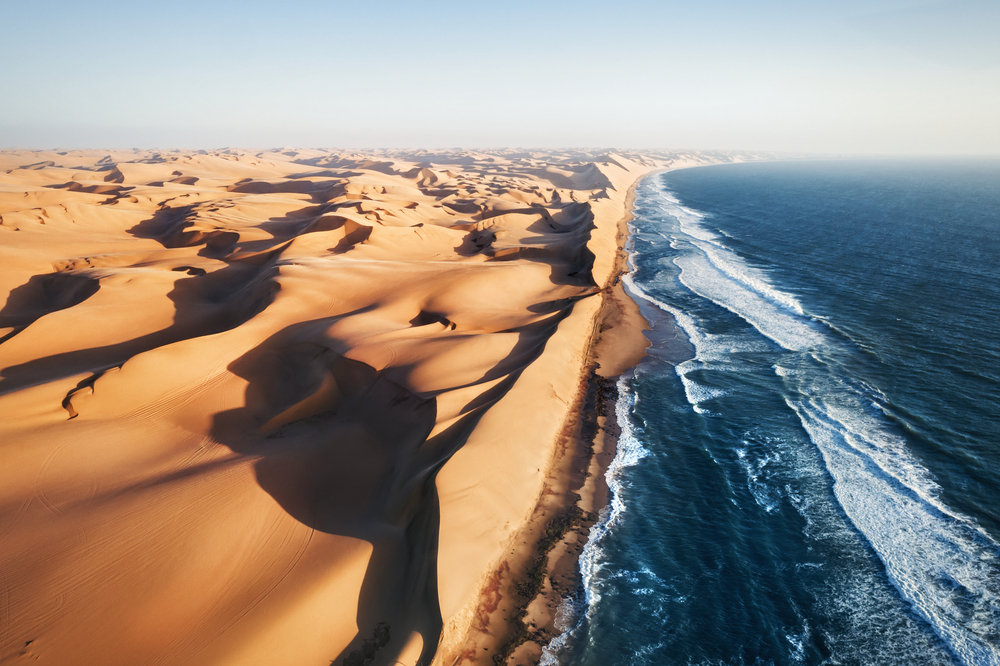 Expansive rolling dunes of the desert where it meets the ocean pictured for a piece on the best time to visit Namibia