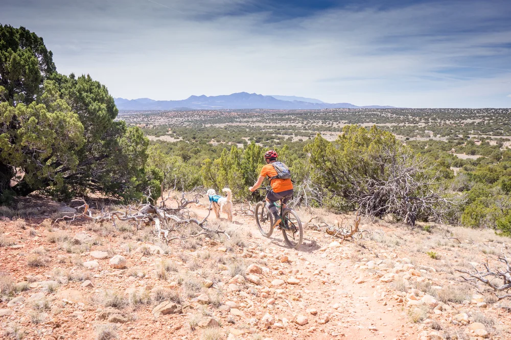 Guy riding his bike in the Galisteo Basin Preserve in April, one of the best times to visit Santa Fe