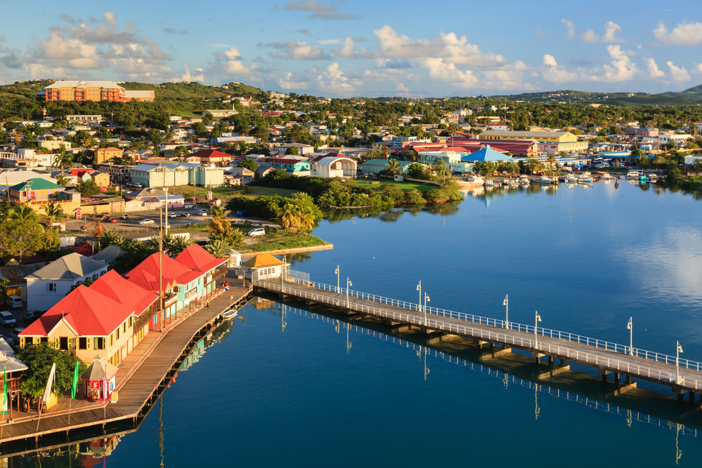 Amazing aerial view with still water showing the boardwalk and harbor of Antigua during the best time to visit with blue sky