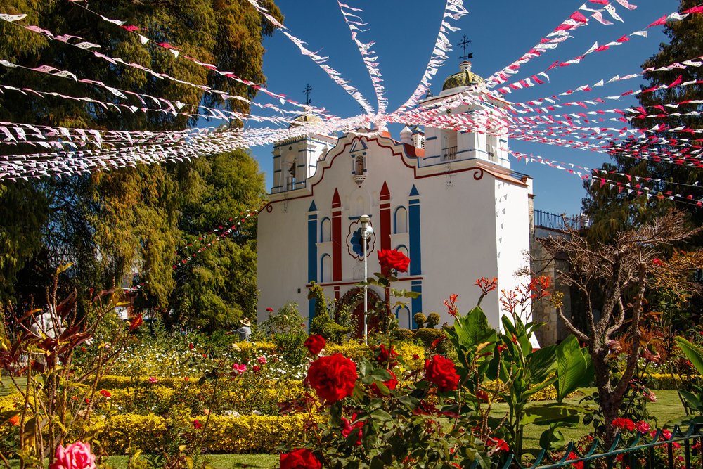 Cool church with flags strung from the peak at the top pictured during the best time to visit Oaxaca