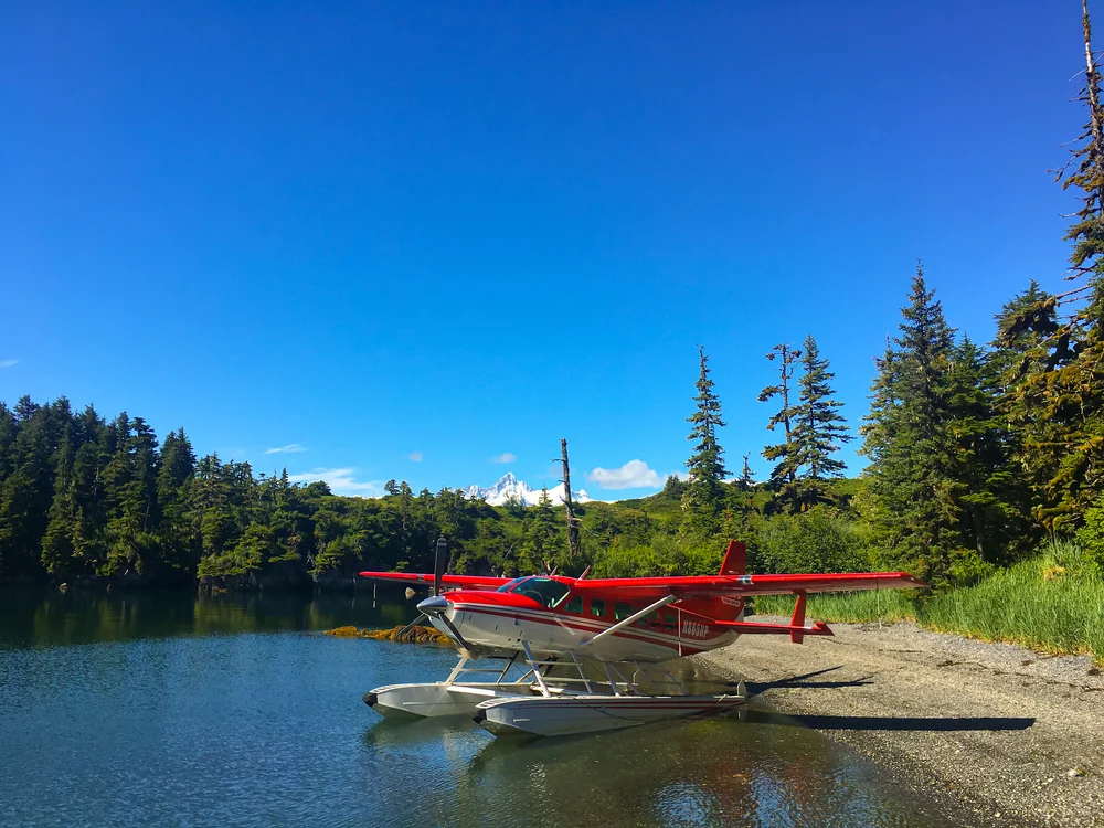 Image of red and white seaplane on the water after landing for a piece on Is Alaska Safe