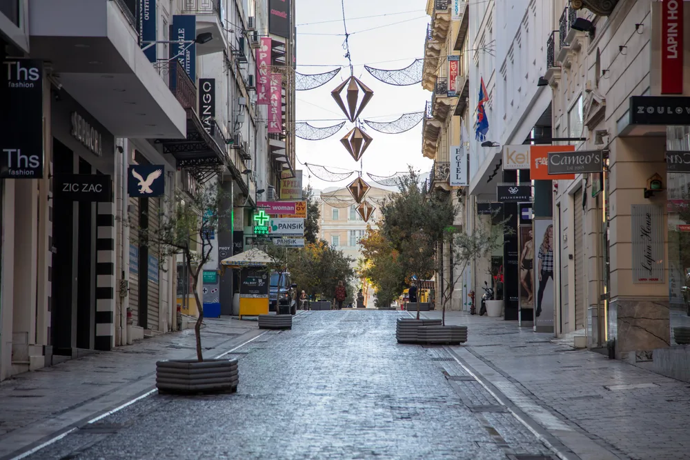 City center with closed shops and hanging outdoor light fixtures during the least busy time to visit Athens Greece