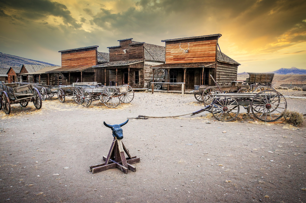 Old wooden wagons in a ghost town pictured during the best time to visit Wyoming