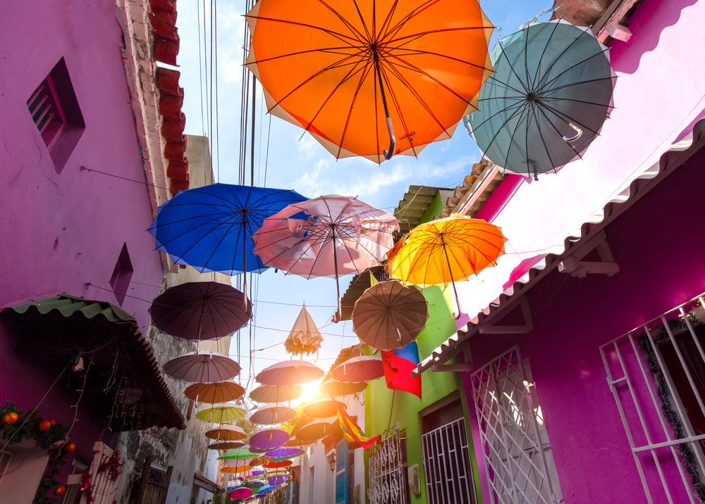 Colorful umbrellas cover a Getsemani street near the Walled City to show why you should visit Cartagena