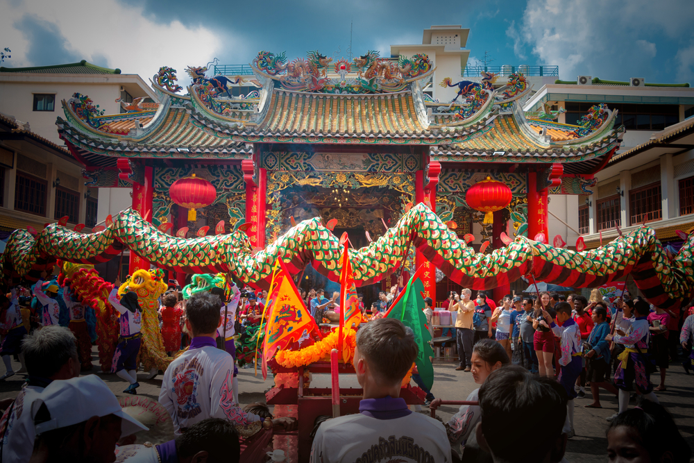Extremely colorful show with a big dragon in front of a temple during the Chinese New Year, pictured during the best time to visit Bangkok