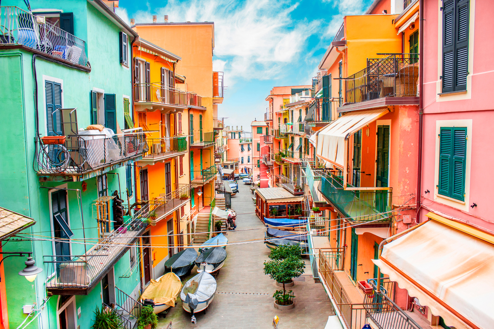 View of street with colorful houses in Manarola for a piece on where to stay in Cinque Terre
