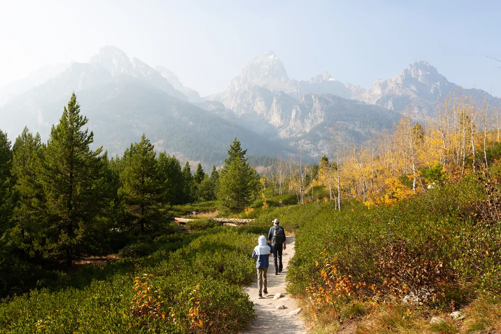 Father and son hiking in Grand Teton National Park during the fall, the least busy time to visit Wyoming
