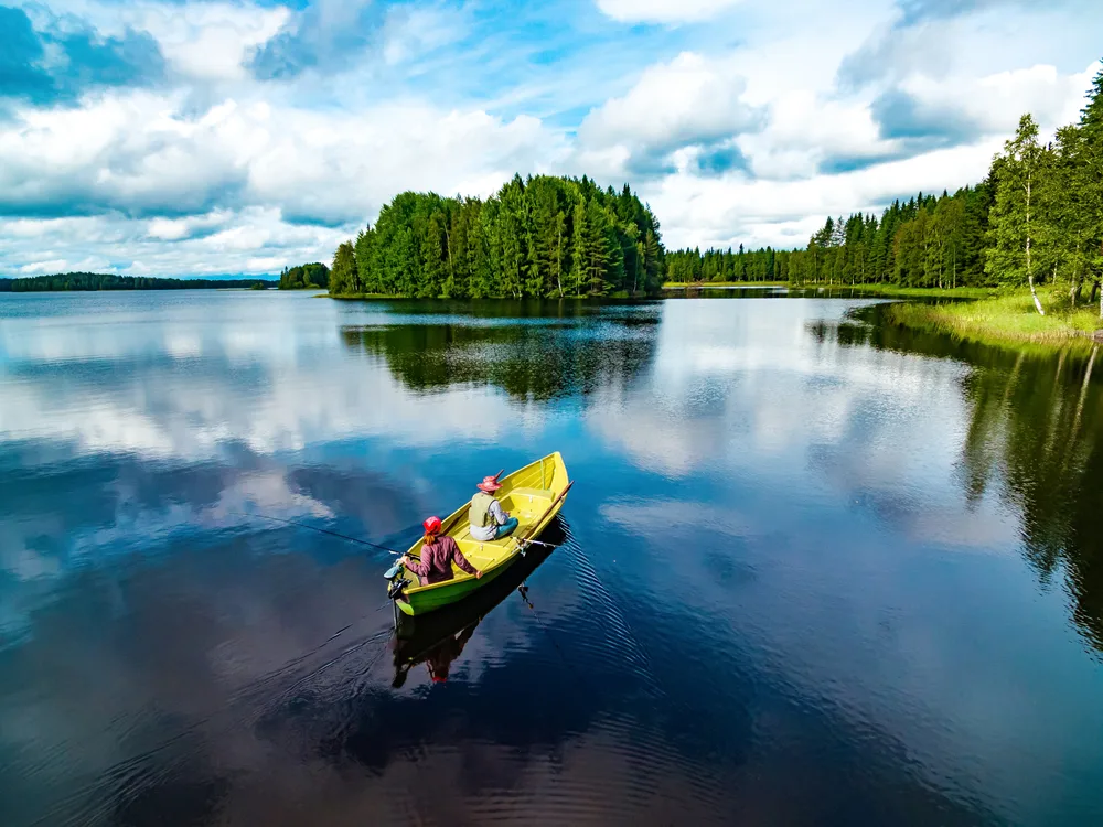 Aerial view of people fishing in a calm Finland lake during summertime
