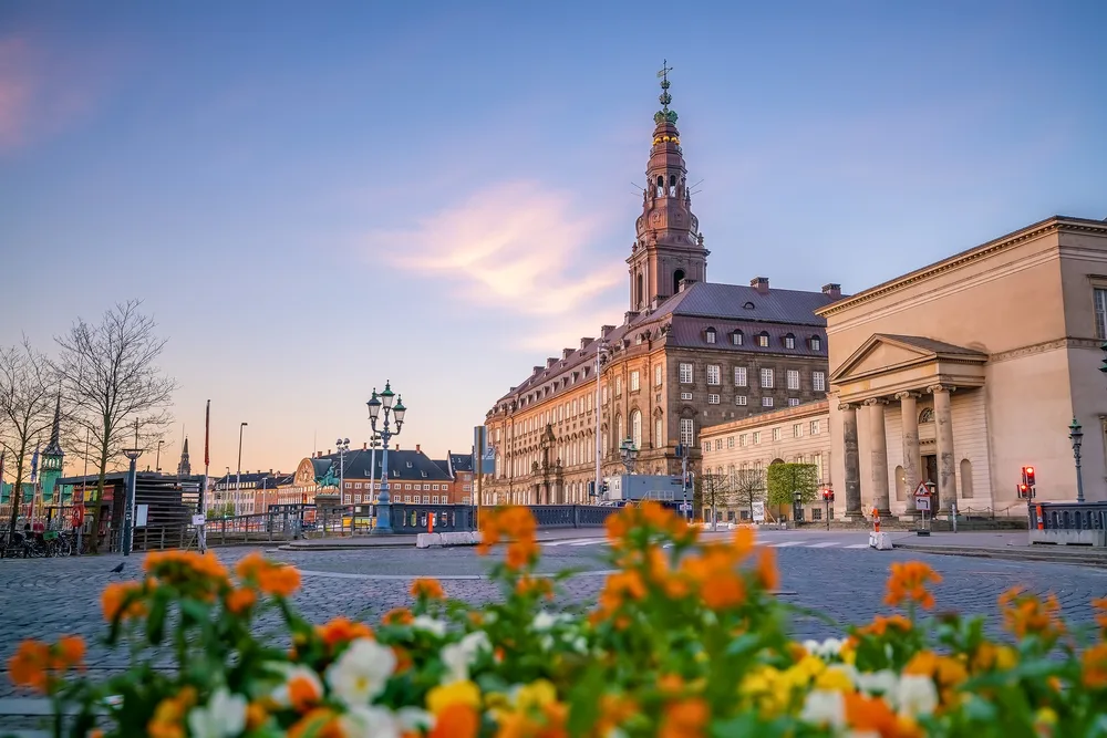 Downtown view with flowers in foreground and clouds in the sky showing the best time to visit Copenhagen