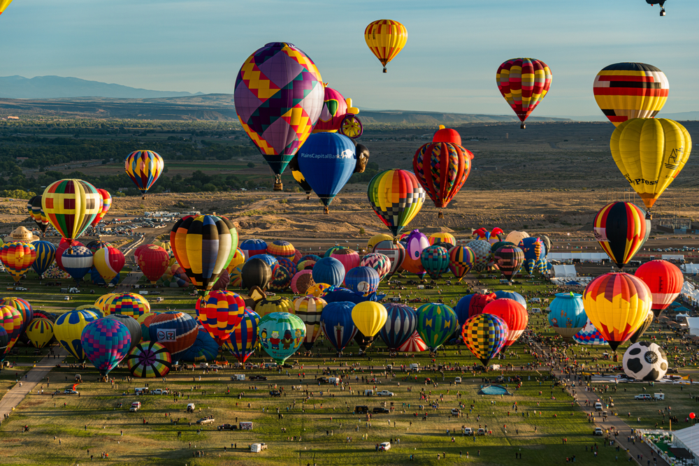 Aerial view of many colorful balloons above the grass areas during the best time to visit Albuquerque