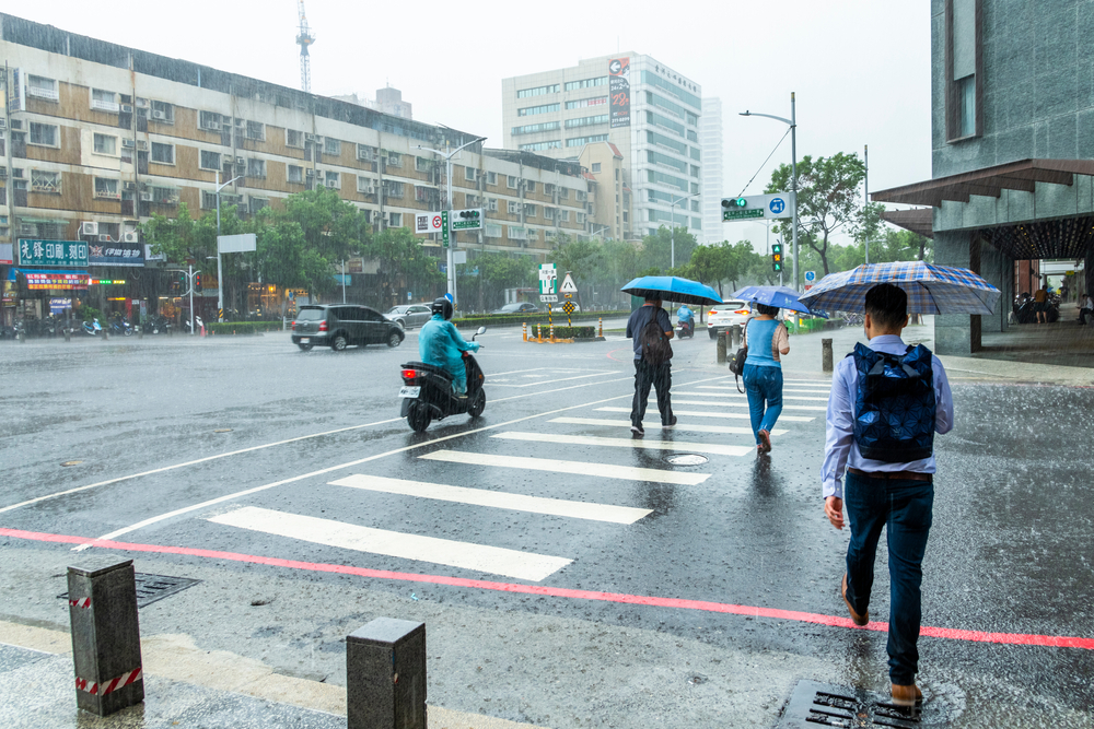 People running around in the rain with umbrellas during the overall worst time to visit Taiwan, May, the rainy season