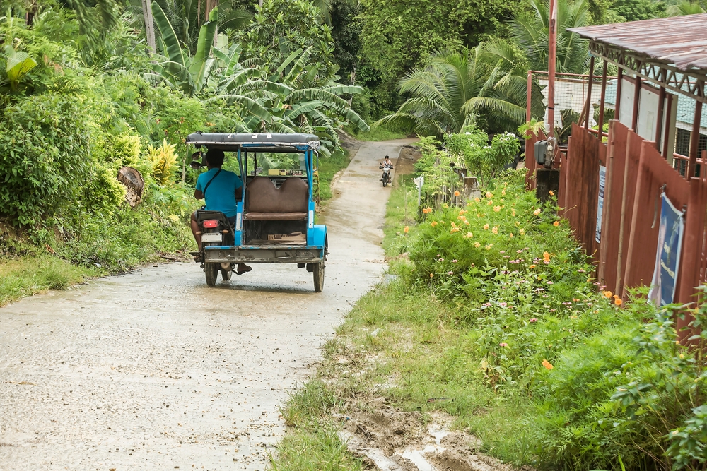 A motorized trike making its way down a rainy hill in the outskirts of town during the rainy season, the cheapest time to visit the Philippines