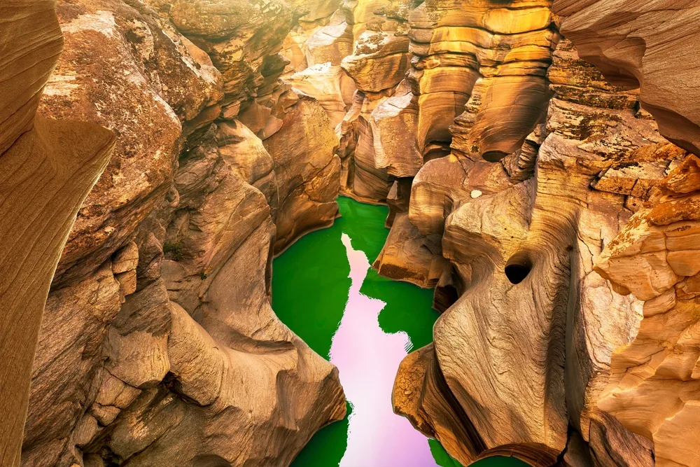 Very neat green water pond pictured during the least busy time to visit Antelope Canyon with sun shining over the ridges