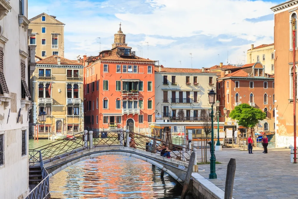 Dorsoduro, a top pick for where to stay in Venice, pictured with a bridge and a river and a town square in the background