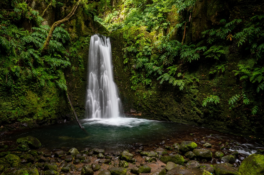 Gushing waterfall in tropical forest during the least busy time to visit the Azores