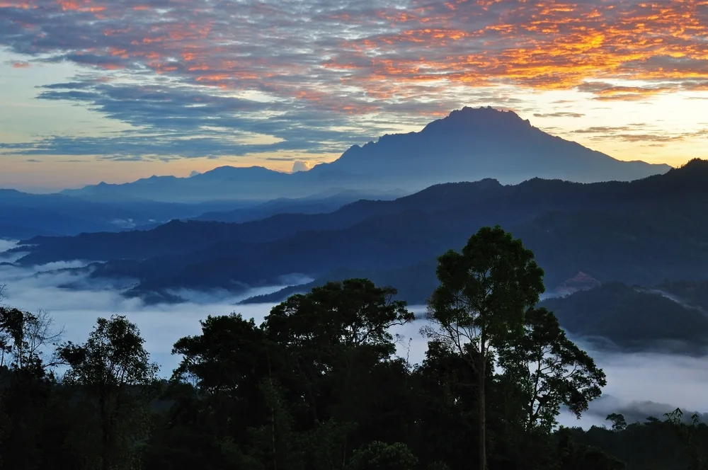 Sunrise aerial view of Mt. Kinabalu showing the cheapest time to visit Malaysia during monsoon season