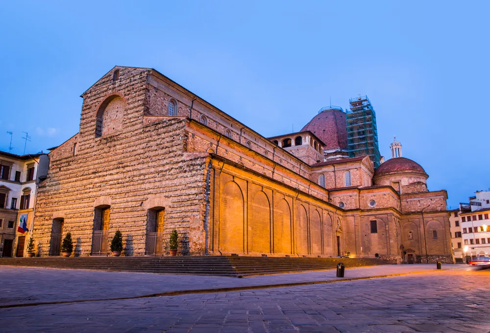 Basilica of San Lorenzo pictured lit up at night for a piece on where to stay in Florence