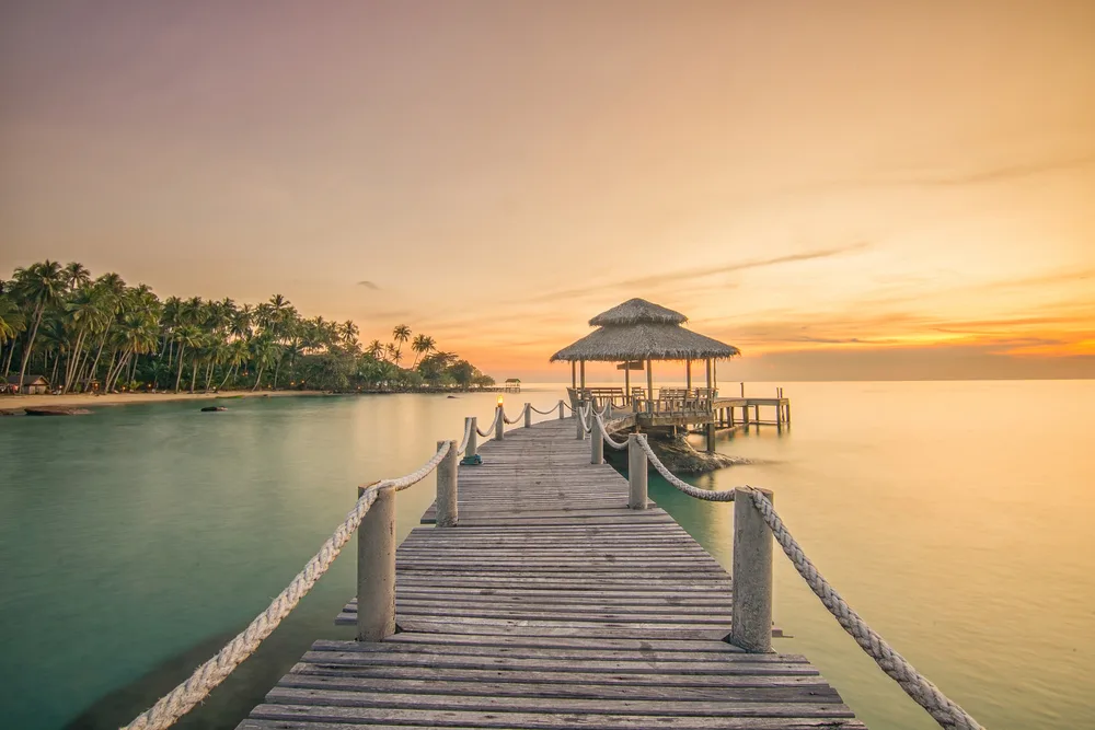 Dock jutting out over the ocean pictured at sunset during the worst time to visit Phuket with empty streets and hot temps