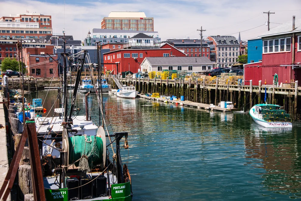 Harbor in the downtown area with boats floating on the water during the best time to visit Portland Maine