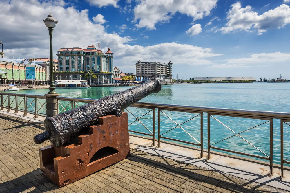 Old cannon on the waterfront boardwalk at Caudan in Port Louis pictured during the cheapest time to visit Mauritius