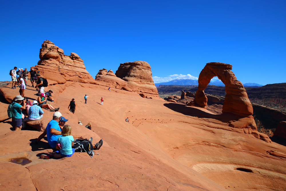 Tons of people crowding in Arches National Park during peak season, the worst time to visit