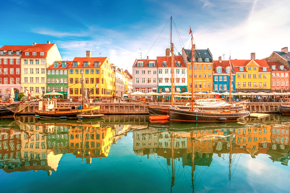 View of colorful houses and boats along the Nyhavn port on a spring day during the least busy time to visit Copenhagen