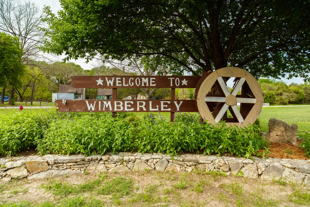 Wimberly welcome sign featuring a wagon wheel shows one of the best places to stay in Fredericksburg