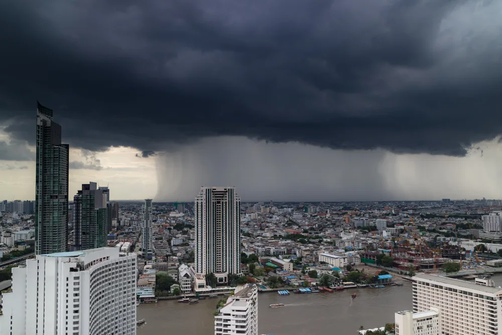 Dark storm cloud hovering over the town during the worst time to visit Bangkok, the rainy months