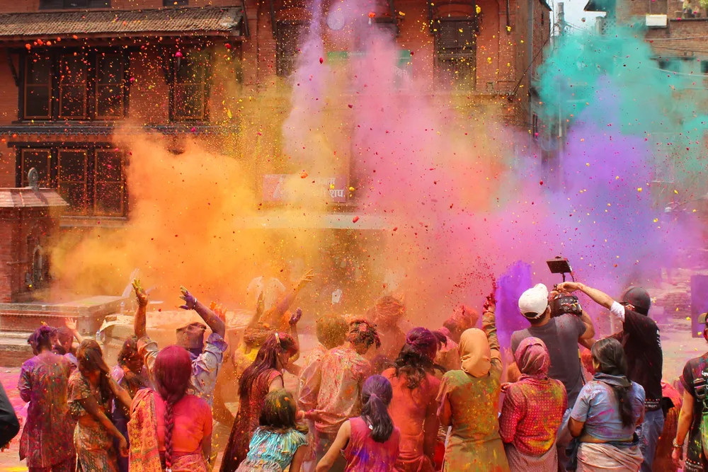 People throwing color in the air during the best times to visit Nepal