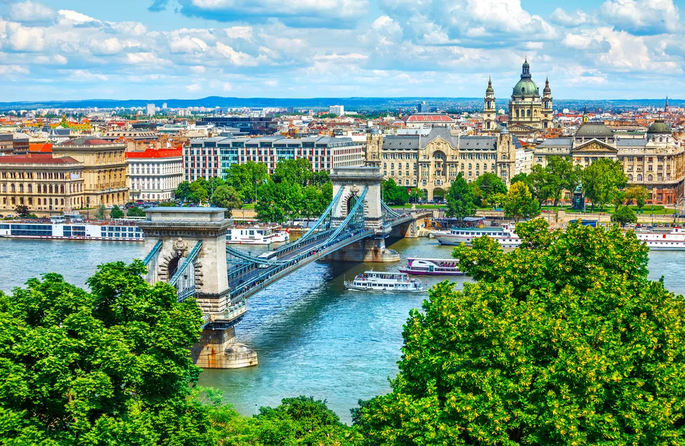 Szechenyi Chain Bridge over the Danube River with greenery and nice weather shows the best time to visit Budapest