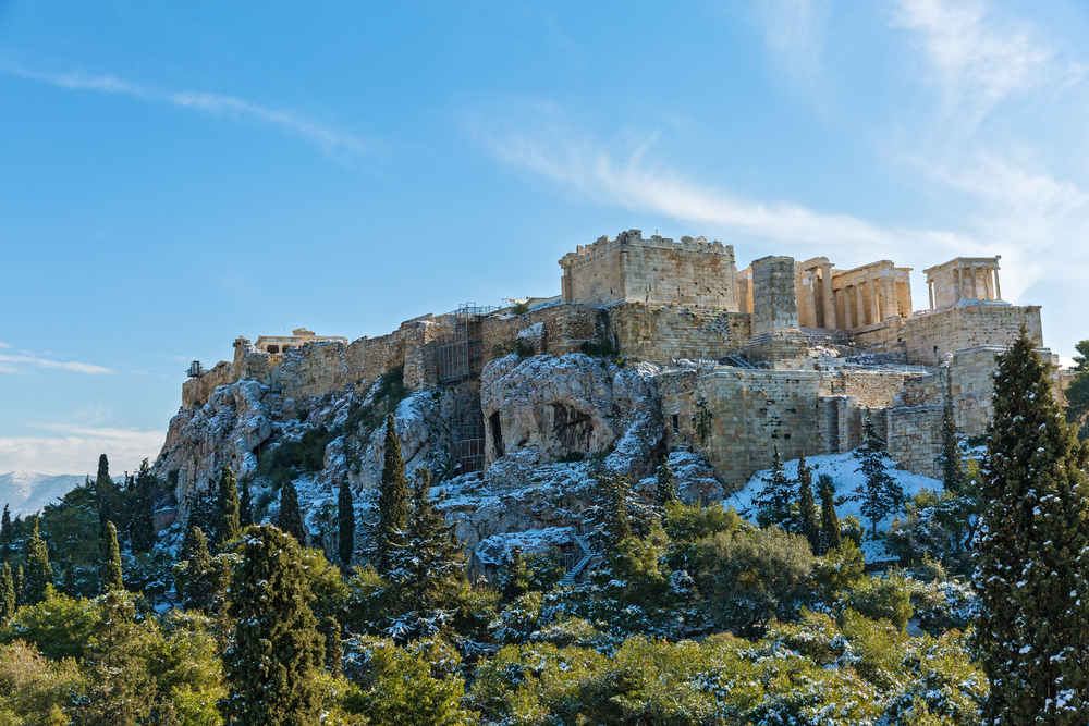 Snow on the Acropolis during the cheapest time to visit Athens, the winter