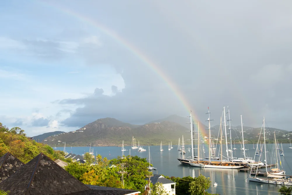 Rain over the harbor with a rainbow during the wet season, the worst time to visit Antigua