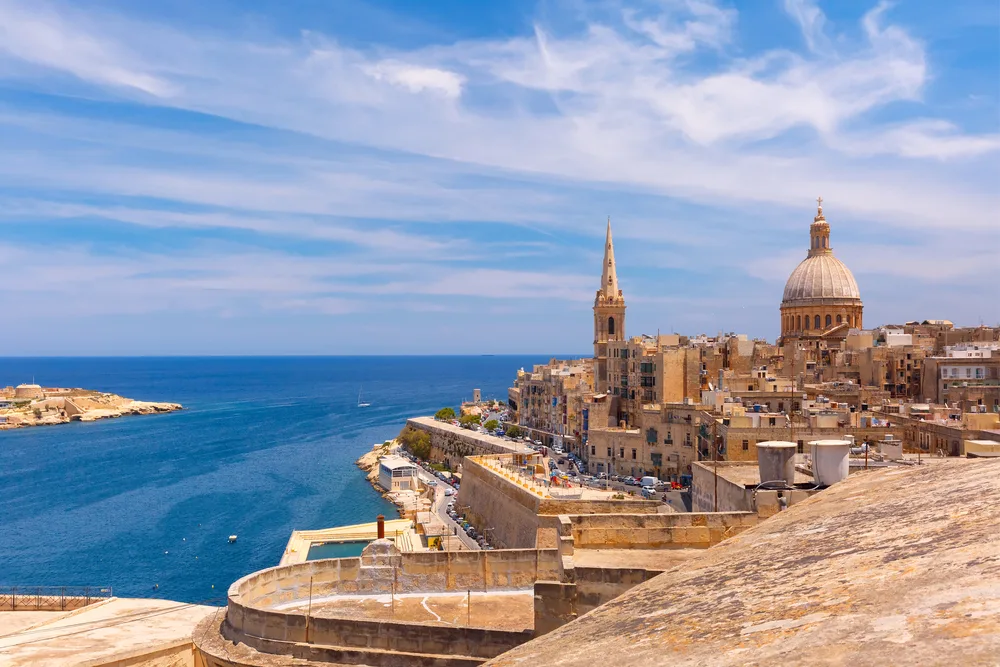 Aerial view of churches in Malta with blue cloudy skies overhead during the best time to visit Malta
