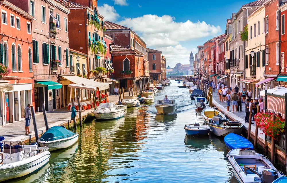 Island Murano with boats lining the canal during the best time to visit Venice