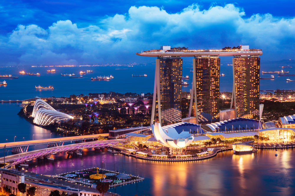 Skyline at dusk with lights glittering everywhere showing the marina bay in Singapore