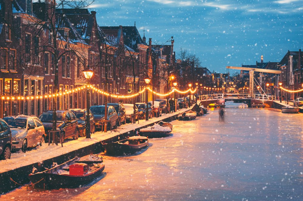 Winter time in Alkmaar with ice on the river and snow falling for a piece on the worst time to visit the Netherlands